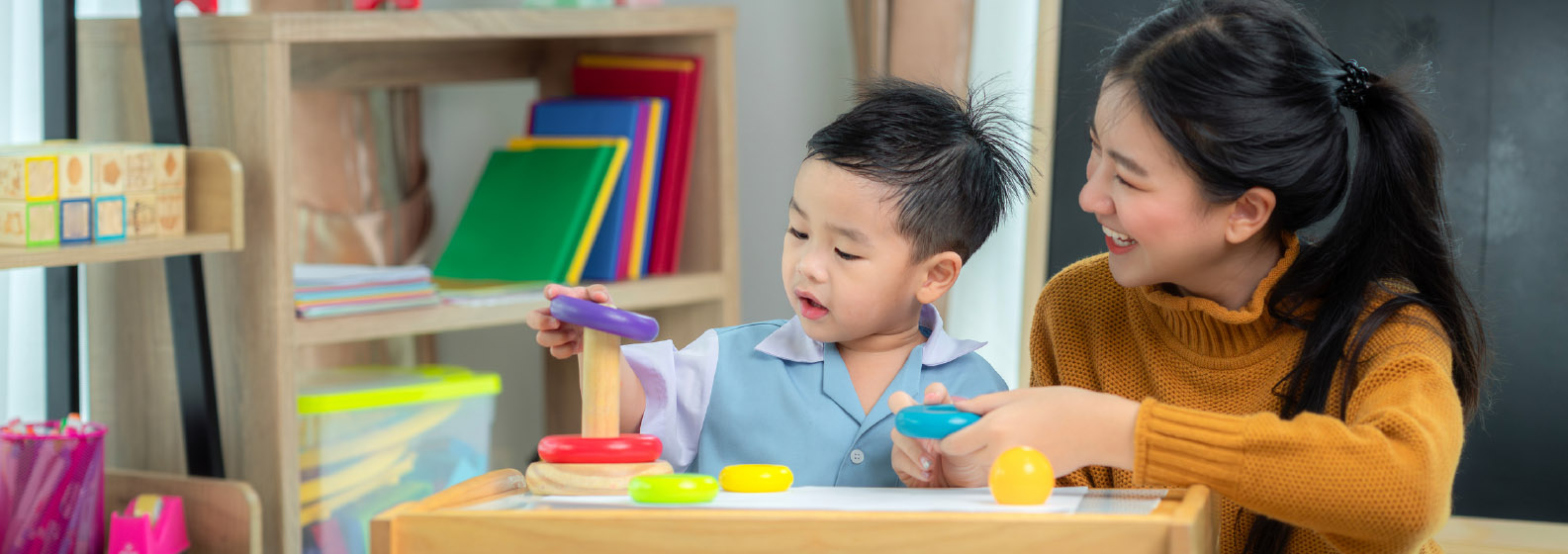 A women and child playing with a toy